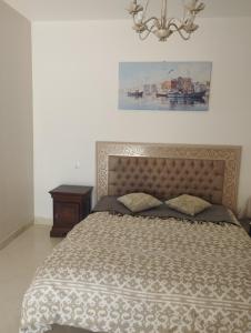 a bedroom with a bed and a chandelier at Résidence soltana Bizerte Vue sur mer in Dar el Koudia