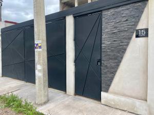 a garage with two large doors on a building at Moderno departamento en Tula in Tula de Allende
