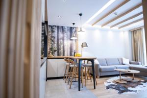 a kitchen and living room with a table and a couch at BiancaNeve Jahorina in Jahorina