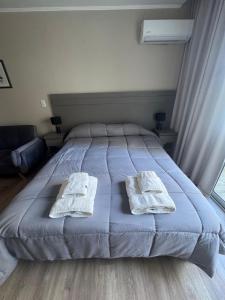 a bedroom with a bed with two towels on it at Apart Pm Casa de playa in Necochea