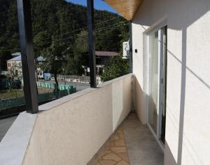 a balcony with windows and a view of a street at მეშვე, MESHVE in Tsʼageri