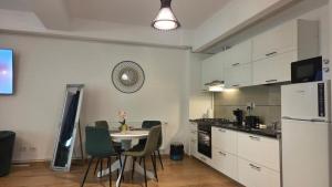a kitchen with a table and chairs and a clock on the wall at Ari Studio Clabucet in Predeal