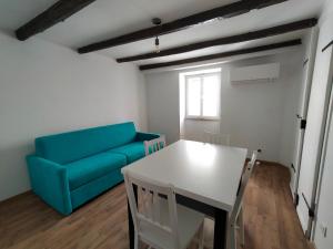 a living room with a blue couch and a table at Casa Petracca in Muggia