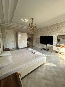 a large bedroom with a large bed and a flat screen tv at Эксклюзивный Дом Самарканда in Samarkand