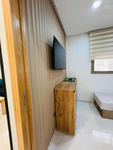 a small room with a bed and a wooden cabinet at Modern Apartment Bouznika in Bouznika