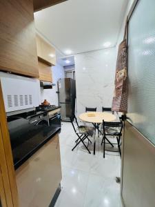 a kitchen with a table and chairs in a room at Modern Apartment Bouznika in Bouznika +5 photos