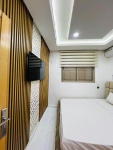 a bedroom with a bed and a tv on a wall at Modern Apartment Bouznika in Bouznika
