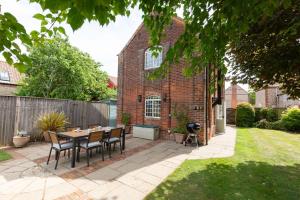 a patio with a table and chairs in a yard at The Bolt House in Little Walsingham