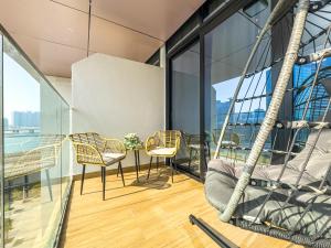 a balcony with chairs and a table and some windows at Charming Studio - Full Canal Views - 5 min walk from ADGM, Cleveland and Galleria - Perfect for Corporate Travelers - Big Balcony - Heart of Maryah Island in Abu Dhabi