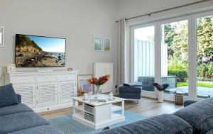 a living room with a couch and a tv at Ostsee Residenz Meeresblick Dünenblick in Insel Poel