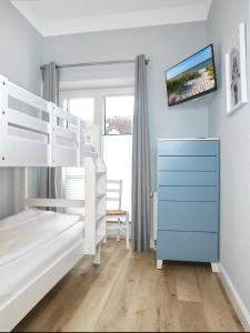 a bedroom with two bunk beds and a blue dresser at Ostsee Residenz Meeresblick Dünenblick in Insel Poel