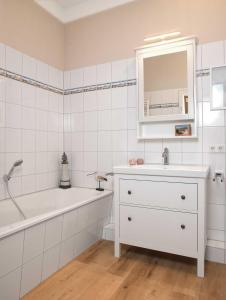 a white bathroom with a sink and a tub and a mirror at Ostsee Residenz Meeresblick Dünenblick in Insel Poel