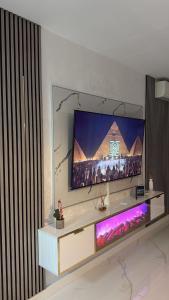 een flatscreen-tv aan een muur in een woonkamer bij Elegance Apartament in Mamaia