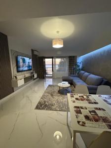 een woonkamer met een bank en een tv bij Elegance Apartament in Mamaia