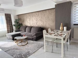 een woonkamer met een bank en een tafel bij Elegance Apartament in Mamaia +54 foto's