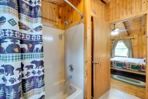 a bathroom with a tub and a shower curtain at Hot Tub and Deck! Bear Hugs Cabin Near Gatlinburg in Glade +27 photos