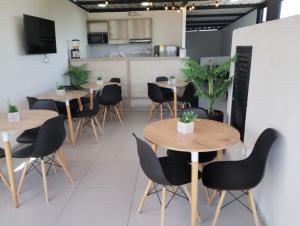 a restaurant with tables and chairs and a kitchen at Hotel Med Llanogrande in Rionegro