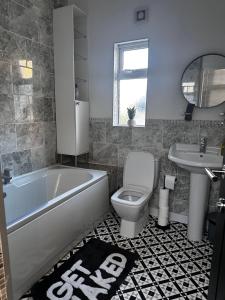 a bathroom with a tub and a toilet and a sink at La Casa de Class - Luxury & Comfort in Cardiff +8 photos