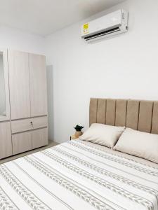 una camera da letto con un letto con un condizionatore sopra di esso di Apartamento Nuevo, Elegante, Cómodo y central a Yopal