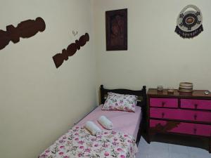 a small bedroom with a bed and a dresser at Quarto suite master para 3 pessoas in Belém