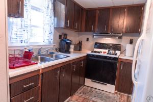 a kitchen with wooden cabinets and a sink and a stove at Slice of Heaven on the Lake 