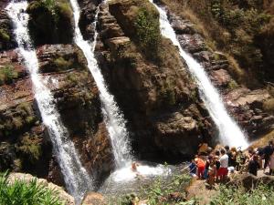 a group of people standing in front of a waterfall at Itiquira Park Hotel in Formosa