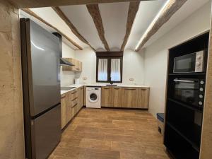 a kitchen with a refrigerator and a washer and dryer at Ca Salvadora in Beniarrés