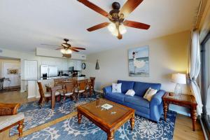 a living room with a blue couch and a table at Emerald Towers West 5001 in Fort Walton Beach