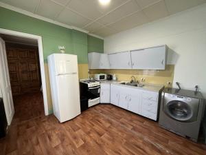 a kitchen with a refrigerator and a washing machine at Inmuebles V&S - Casita Alberdi in Río Gallegos
