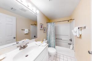 a bathroom with a sink and a toilet and a mirror at Emerald Towers West 5007 in Fort Walton Beach +15 photos
