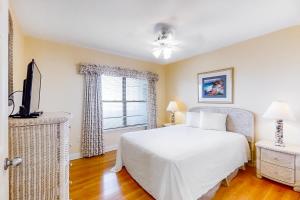 a bedroom with a white bed and a window at Emerald Towers West 5007 in Fort Walton Beach