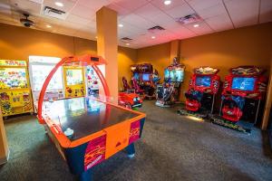 una habitación con varios juegos de arcade y una mesa en Pool view Condo near all Parks, en Orlando