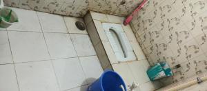 uma casa de banho com um WC e uma parede de azulejos em Singh-Sadan PG HomeStay em Pune mais 15 fotografias