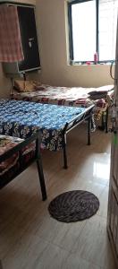 um quarto com duas camas e uma mesa em Singh-Sadan PG HomeStay em Pune