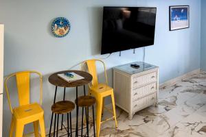 a living room with a table and chairs and a tv at Fontainebleau 305 in Panama City Beach