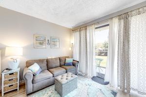 Una sala de estar con un sofá y una ventana grande. en Pirates Bay B102, en Fort Walton Beach