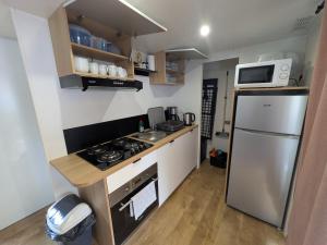 una piccola cucina con fornelli e frigorifero di Mobil-Home 4-6 personnes camping 4 étoiles a Capbreton Altre 3 foto