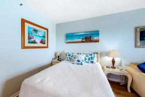 a bedroom with a white bed and blue walls at Pirates Bay A215 in Fort Walton Beach +14 photos