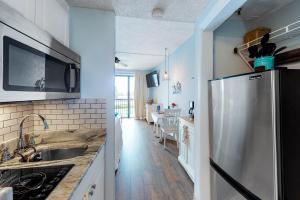 a kitchen with a sink and a refrigerator at Pirates Bay A215 in Fort Walton Beach