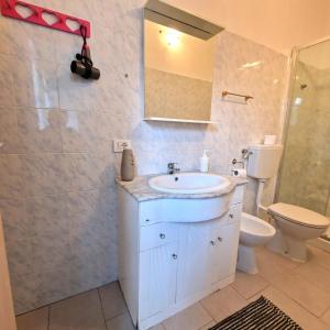 a bathroom with a sink and a toilet and a mirror at Arco Iris Locazioni turistiche in Mestre