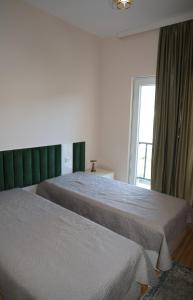 two beds in a hotel room with a window at მეშვე, MESHVE in Tsʼageri