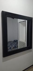 un miroir accroché au mur dans une pièce dans l'établissement Malindu Restaurant & Rooms, à Katunayake