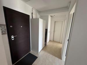 a hallway with a black door and a hallway with white walls at Blue Oasis in Ştefăneştii de Sus