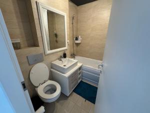 a bathroom with a toilet and a sink and a tub at Blue Oasis in Ştefăneştii de Sus