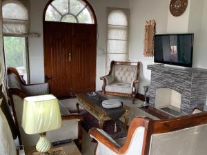 sala de estar con TV, silla y mesa en 3 Bed Luxury House with Valley Views & Privacy, en Murree