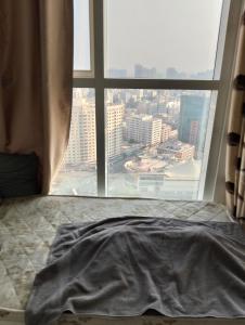 un letto in una camera con una grande finestra di عجمان هايتس ad Ajman