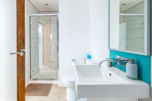 a bathroom with a white sink and a shower at Sedum House in Gimingham +50 photos