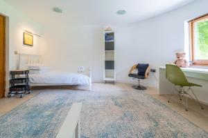 a bedroom with a bed and a desk and chairs at Sedum House in Gimingham