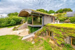 a house with a green roof on top of a hill at Sedum House in Gimingham