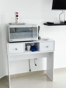 einen weißen Tisch mit einer Mikrowelle darüber in der Unterkunft Modern Studio Apartment in downtown Yopal in Yopal
